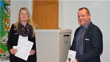 Maren Würger und Kai Littmann stehen zusammen an einer Wahlurne.