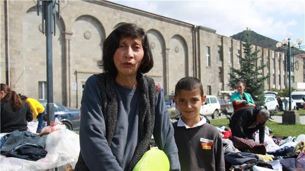 Margarita (l) und ihr Enkel Tigran sammeln nach der überstürzten Flucht aus Berg-Karabach Kleider.
