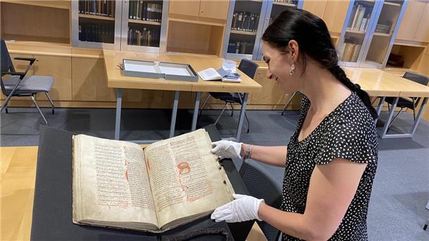 Eine Frau schaut auf ein altes Buch.