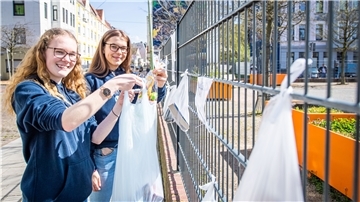 Marie Speckmann (links) und Rieke Klemm bestücken den Spendenzaun am Leher Pausenhof - dem Treffpunkt des neuen Vereins „Havenkidz“.