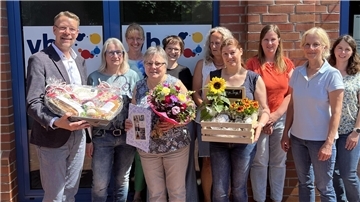 Marina Wohlers (3. von links, vorne) wurde von VHS-Leiterin Andrea Stephan (3. von links, hinten) und VHS-Geschäftsführer Henning Fricke im Beisein der Mitarbeitenden in den Ruhestand verabschiedet.