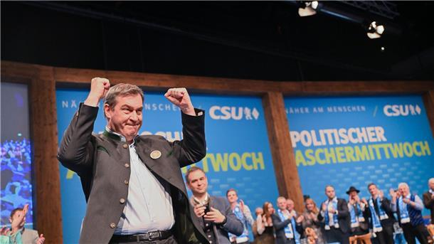 Markus Söder mit emporgereckten Armen.