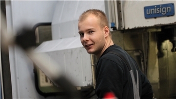 Marlon Moderow aus Kirchtimke steht an einer CNC-Fräsmaschine und passt ein Schraubteil für sein Werkstück an.