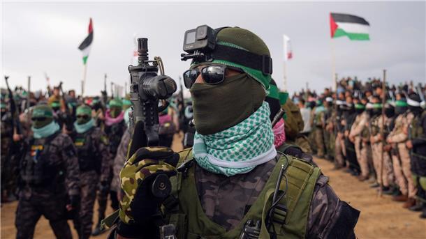 Bilder des Tages Martialischer Auftritt: Vermummte und bewaffnete Kämpfer der Terrororganisation Hamas gehen in Stellung, bevor sie die Leichen von vier israelischen Geiseln, darunter eine Mutter und ihre beiden Kinder, die seit langem für tot gehalten wurden, dem Roten Kreuz in Chan Junis im südlichen Gazastreifen übergeben wollen.