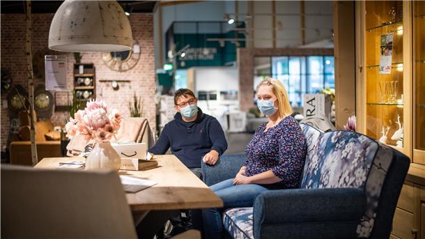 Marvin und Yvonne Holst sehen sich im Möbelhaus ein Küchensofa an.