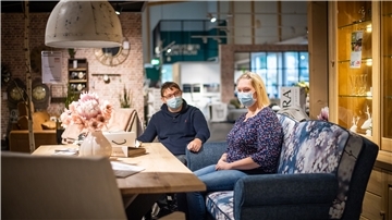 Marvin und Yvonne Holst sehen sich im Möbelhaus ein Küchensofa an.