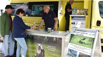 Matthias Ahlbrecht (dritte Person von links), Bundesfreiwilliger beim VSR-Gewässerschutz, berät Brunnenbesitzer am Informationsstand des Labormobils. Harald Gülzow (vierte Person von links) analysiert eine Wasserprobe auf den Nitratgehalt.