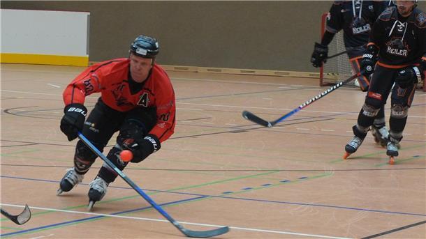 Ein Inline-Hockeyspieler fährt übers Feld.