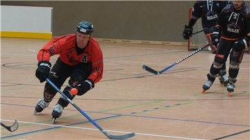 Ein Inline-Hockeyspieler fährt übers Feld.