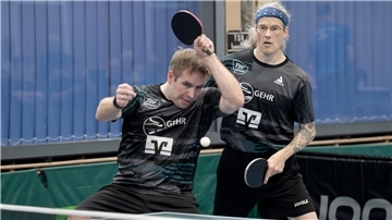 Zwei Männer spielen ein Tischtennis-Doppel.