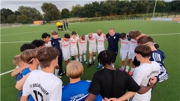 Max Janßen bespricht mit seinen Jungs den Sieg und die Rote Karte gegen Collin Noah Bellmer (Nr. 17). Im Hintergrund versucht Co-Trainer Mo Kassim noch, Schiedsrichter Focht umzustimmen. Ohne Erfolg.