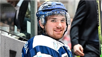 Ein Eishockey-Spieler sitzt auf einer Bank.