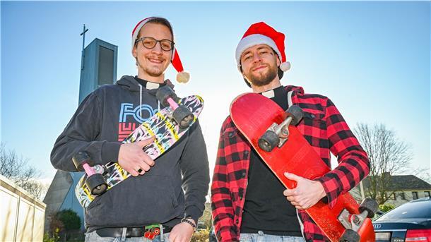 Zwei Männer mit Skateboard vor einer Kirche.