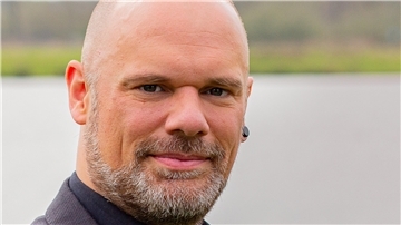Mann mit Bart, Glatze und Ohrstecker