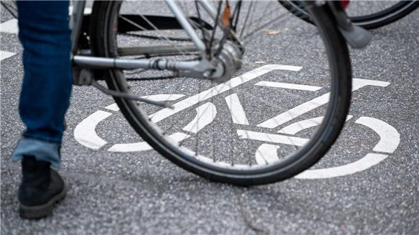 Ein Fahrradfahrer steht auf der Straße auf einem Fahrradpiktogramm.