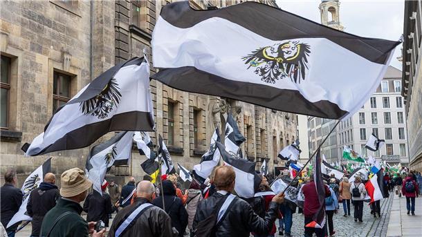 Mehrere hundert Teilnehmer einer Demonstration ziehen mit Flaggen vom Königreich Preußen (schwarz-weiß-schwarz mit Adler) durch die Innenstadt.
