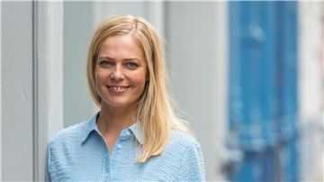 Eine Frau mit blauer Bluse.