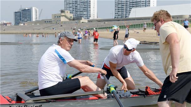 Meiko Remmers (Mitte), Europameister im Küstenrudern aus Aurich, hilft seinem Vater Wiard Cordes im Beachsprint-Wettbewerb beim Einsteigen ins Boot und beim Start. 