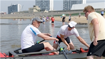 Meiko Remmers (Mitte), Europameister im Küstenrudern aus Aurich, hilft seinem Vater Wiard Cordes im Beachsprint-Wettbewerb beim Einsteigen ins Boot und beim Start. 