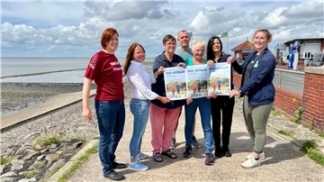 Gruppenfoto von sieben Personen, die drei Plakate für den 1. Butjenter Küstencrosslauf hochhalten