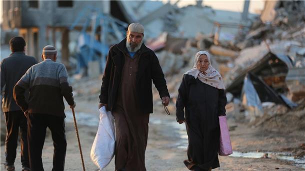 USA: Tote nach Huthi-Angriff auf Frachtschiff Menschen gehen an zerstörten Gebäuden im Flüchtlingslager Al-Maghazi im Zentrum des Gazastreifens vorbei. Das Bangen um eine Feuerpause vor Ramadan geht weiter.