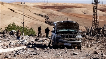 Menschen inspizieren die Trümmer eines Elektrizitätswerks in Nordsyrien, das durch türkische Luftangriffe zerstört wurde.