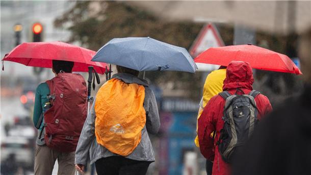 Neue Woche bringt Wolken: Regen wahrscheinlich ab Dienstag Menschen schützen sich bei Regen mit ihren Schirmen.