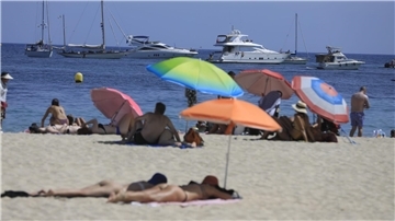 Menschen sonnen sich am Strand von Magaluf.