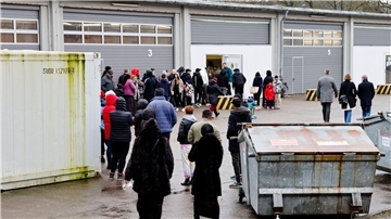 Menschen stehen Schlange bei der Essenausgabe in der Landesunterkunft der Gemeinde Seeth im Kreis Nordfriesland.