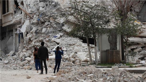 Ein Monat nach den Beben: „Die Zukunft ist vorbei“ Menschen stehen vor den Trümmern eines Gebäudes, das bei dem jüngsten Erdbeben in Aleppo zerstört wurde.