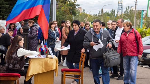 Ukrainische Gebiete: Erste Ergebnisse nach Scheinreferenden Menschen stellen sich in einer Reihe auf, um an einem Scheinreferendum in Luhansk teilzunehmen.