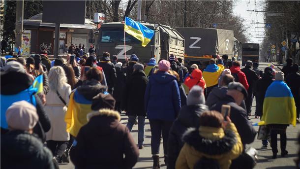 Menschen tragen während einer Kundgebung in Cherson ukrainische Fahnen (Archivbild März 2022).