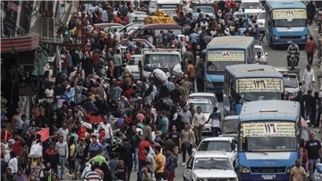 Menschen und Fahrzeuge drängen sich auf dem beliebten Straßenmarkt von Al Ataba in Kairo.