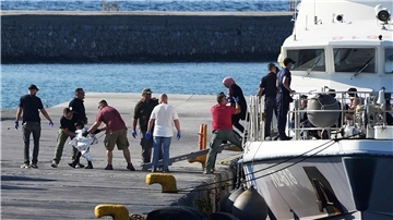 Menschen werden nach der Rettungsaktion im Hafen von Mytilini auf Lesbos von Beamten der Küstenwache eskortiert.