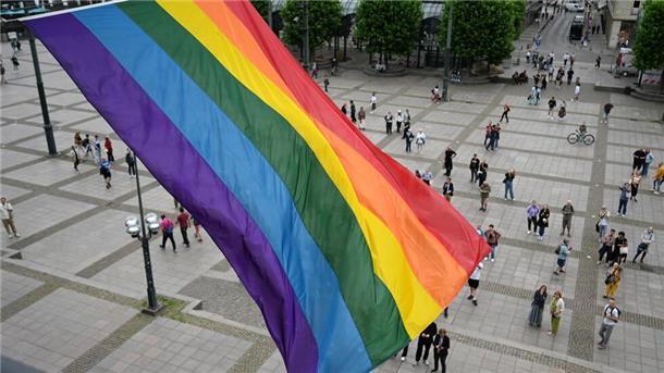 Eine Regenbogenflagge weht an dem Balkon des Hamburger Rathauses.