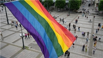 Eine Regenbogenflagge weht an dem Balkon des Hamburger Rathauses.