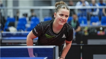 Eine Tischtennisspielerin steht an einer Tischtennisplatte.