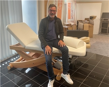 Mann sitzt auf Massageliege