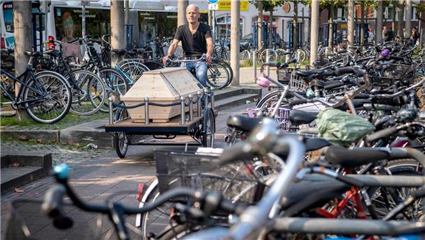Mann mit Bestattungsfahrrad.