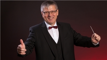 Michael Ruf dirigiert mit einem Taktstock.