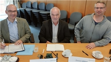 Drei Männer sitzen an einem Tisch
