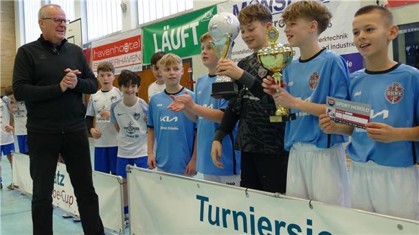 Michael Söhlke, Regionaldirektor der AOK Bremen-Bremerhaven, übergab Torhüter Gabriel Vogler den Siegerpokal und einen Gutschein für Sport Herold über 175 Euro.