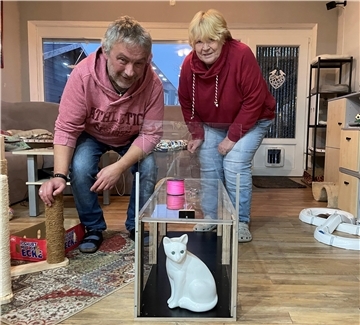 Ein Paar mit einer Katzenfalle im Wohnzimmer