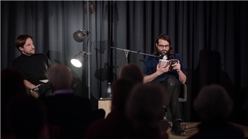 Michel Decar (rechts) stellt den Zuhörern am vierten Abend der Literarischen Wochen den Taugenichts vor, der in dem satirischen Künstlerroman „Kapitulation“ das Schreiben aufgeben will. Da hört nicht nur Tobias Pollok, der Kulturreferent der Arbeitnehmerkammer, aufmerksam zu.