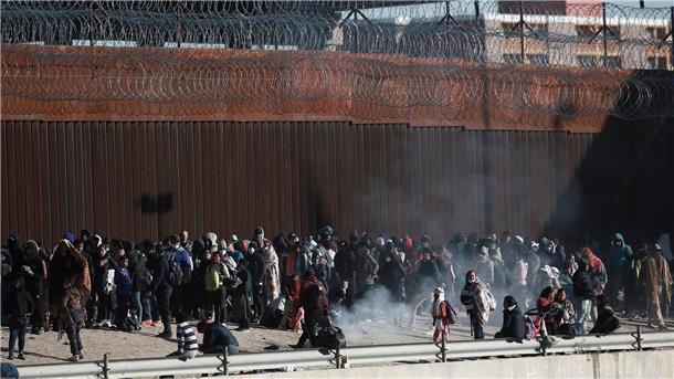 Umstrittene US-Abschieberegelung bleibt vorerst in Kraft Migranten aus Lateinamerika stehen an der Grenzmauer zwischen Mexiko und den USA.