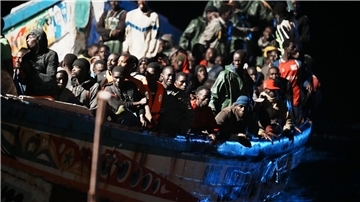 Migranten befinden sich dicht gedrängt in einem Holzboot (Archivbild).
