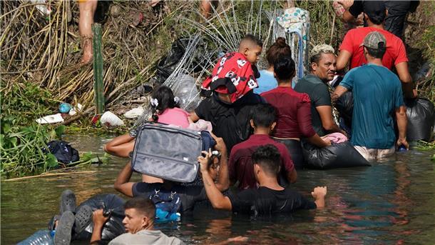US-Abschieberegelung läuft aus: Migranten strömen an Grenze Migranten durchqueren den Grenzfluss Rio Grande zwischen Mexiko und den USA.