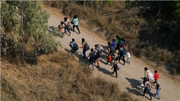 Migranten gehen im Süden von Texas über einen Feldweg, nachdem sie die Grenze zwischen den USA und Mexiko überquert haben.