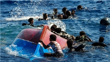 Migranten schwimmen neben ihrem umgestürzten Holzboot im Mittelmeer (Archiv).