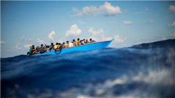 Migranten sitzen in einem Holzboot im Mittelmeer nahe der Insel Lampedusa: Die kleine Insel gehört seit Jahren zu den Brennpunkten illegaler Migration (Archivfoto).